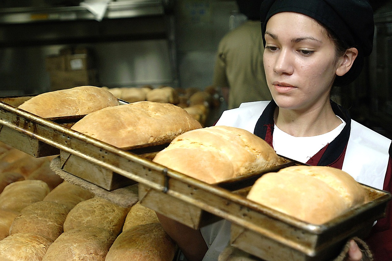 Baker holding bread pans